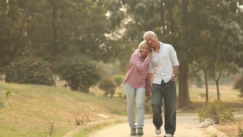 Old Asian Couple Enjoys A Peaceful Walk in the Park Together