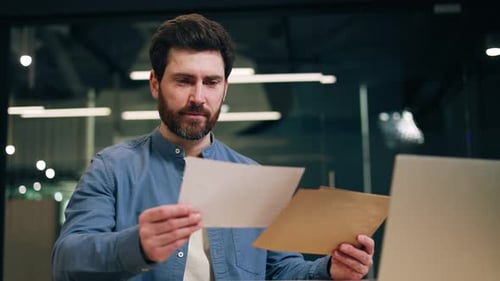 Male Employee Receiving Letter with Great News and Feeling Delighted in Office