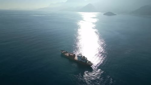 Cargo Ship Sailing on Blue Ocean in Sunlight