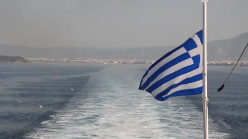 Filmando a bandeira grega enquanto viaja com um cruzeiro. Linda bandeira e mar com gaivota voando