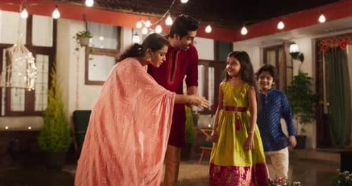 Family Lighting Candles in Courtyard at Night