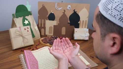 Man Praying During Ramadan with Gifts and Book