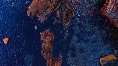 Aerial View of Rocky Coastline and Deep Blue Sea