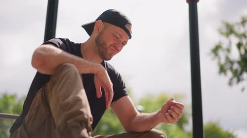 Urban Casual Moment Man Relaxing Outdoors With Phone City Dweller Resting While Checking Device