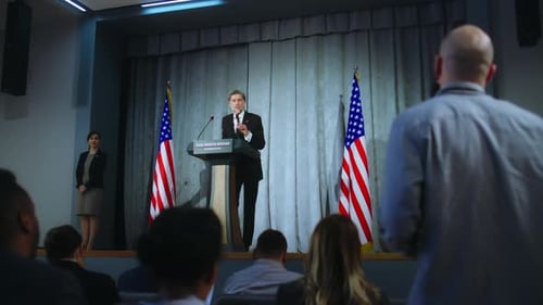 Man Presenting at Podium with American Flags