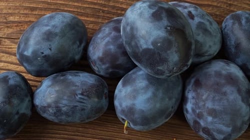 Fresh Ripe Plums on Rustic Wooden Surface