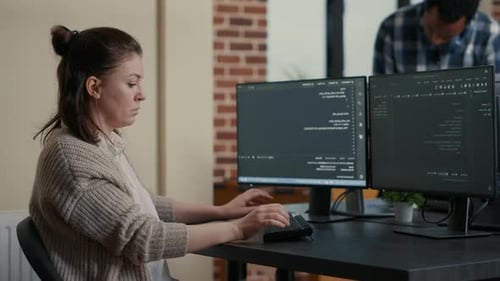 Software Developer Develops Software at Computer Desk