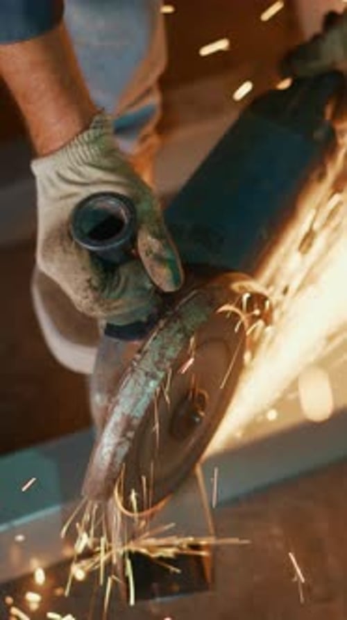 A Closeup View of a Person Using an Angle Grinder Showcasing Sparks Flying From Metal As They Cut