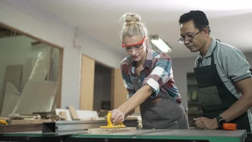 Carpenters are working together at workshop.