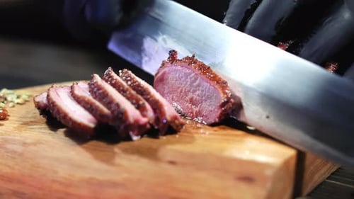 Meat Slices Being Prepared with Silver Knife