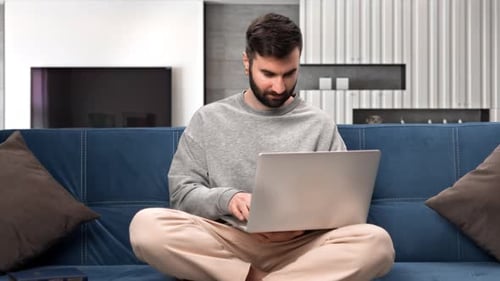Man Working on Laptop Computer At Home