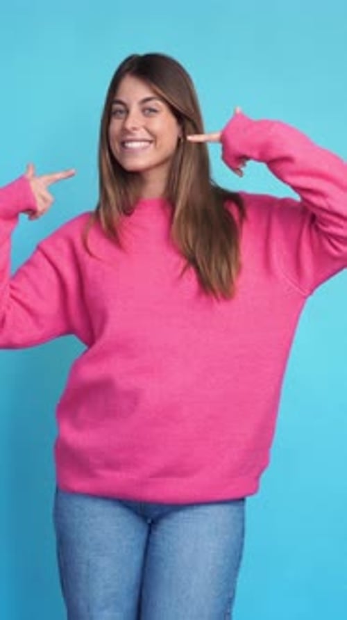 Cheerful Woman Smiling and Pointing to Cheeks