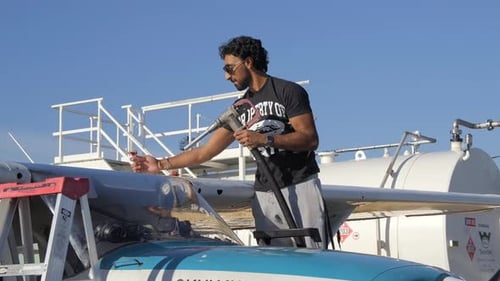 Man Refuels Small Airplane on a Clear Day