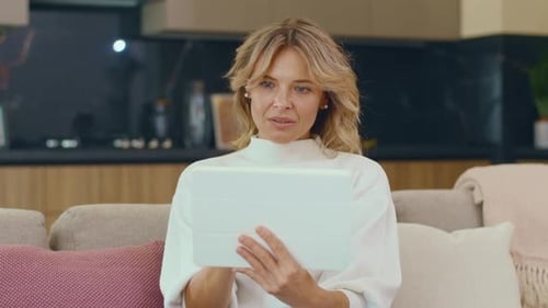 Woman Using Tablet Device on Couch at Home