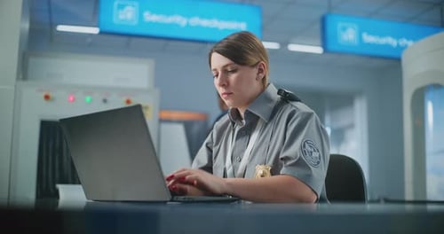 Airport Security Female TSA Officer Using Laptop Smiling and Looking at Camera