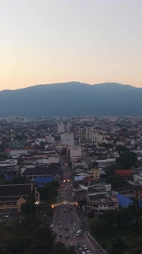 Vertical Aerial View of Urban Skyline With Mountain Backdrop at Sunset