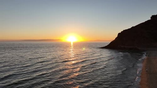Zumbido aéreo disparado hacia el sol junto a una colina