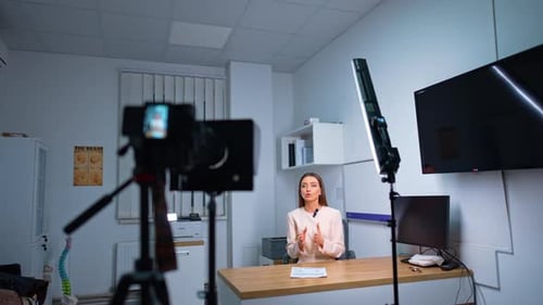 Woman Recording Video in Office at Desk