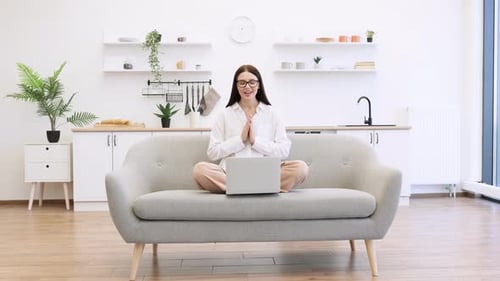 Woman Meditating While Working on Portable Laptop at Living Room