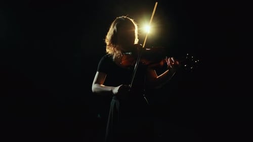 Backlit Woman Playing Violin on Dark Stage