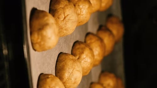 Round homemade cookies are baked in the oven. Vertical video