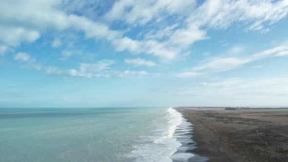 Aerial reverse above breaking waves at vast Kaitorete Spit (New Zealand ...