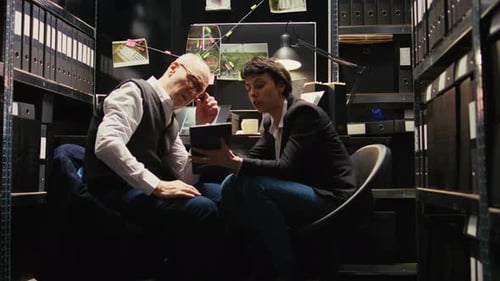 Investigators Reviewing Tablet in Small Office