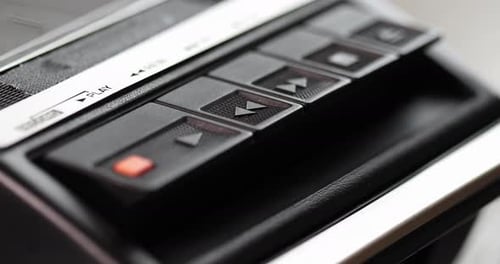 Die Wiedergabetaste eines alten Vintage-Kassettenspielers wird gedrückt (Makro)