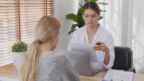 Woman Doctor Talking with Patient in Office