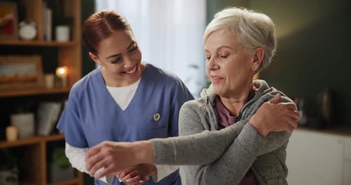 Therapist Helping Senior Woman Stretching Arm