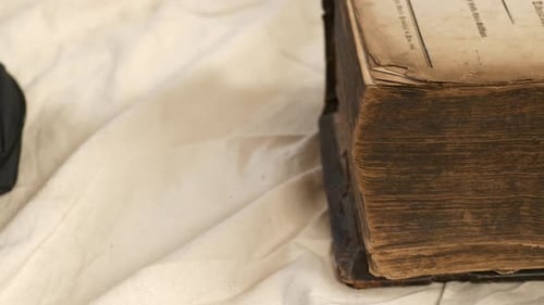 Close up of cover of thick old book with worn edges being shut. Static shot.