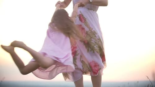 Mother and Daughter Playing Outdoors at Sunset
