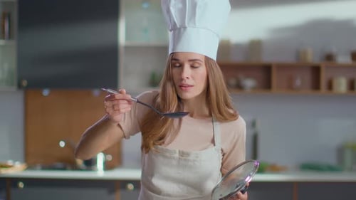 Woman Chef Tasting Food in Kitchen
