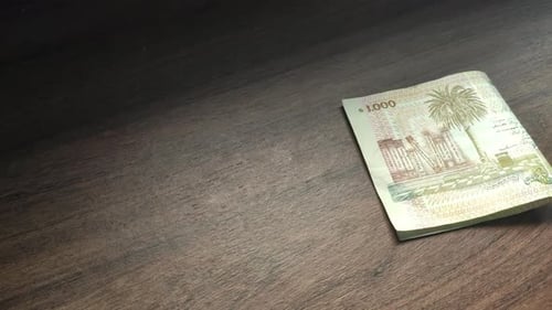 White hand taking money on a table