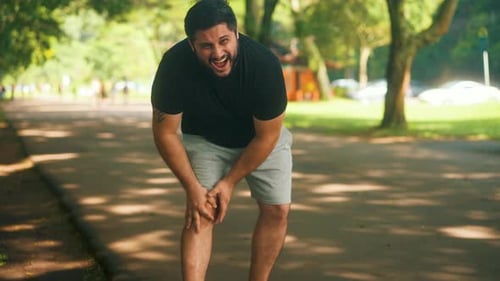 Man Holds Knee in Pain After Park Workout