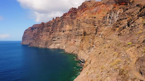 Aerial spectacular view of Los Gigantes. Drone flight over huge cliff rocks. Tranquil deep blue wate