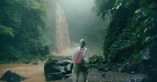 Person Hiking to a Waterfall in Tropical Jungle