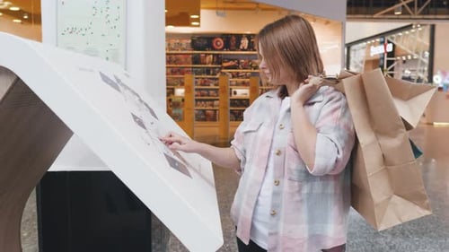 Mädchen studiert einen Kartenplan in einem modernen Einkaufszentrum