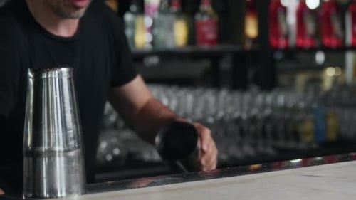 Bartender Preparing Drink at a Bar with Shakers