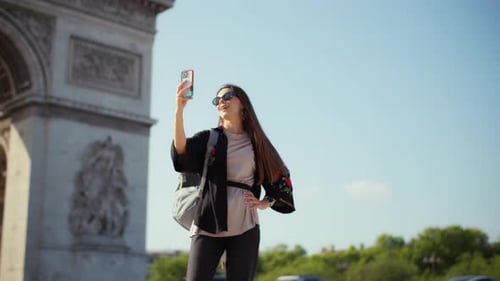 Young Woman Traveler Near Arc De Triomphe in Paris Taking Photo