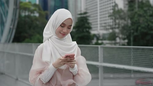 Portrait of Arabian Young Smiling Girl Standing Outside Street and Using Cell Phone
