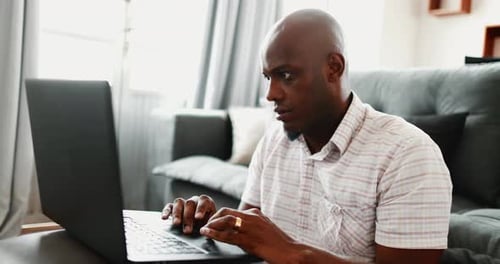 African man using laptop computer at home