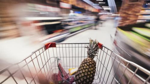 Time Lapse of Shopping Cart Moving Between Aisles and Sections of Supermarket Full of Healthy Food