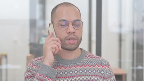 Young Adult Talking on Mobile Phone Indoors