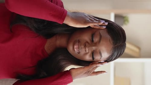 Young Woman Experiencing Headache, Holding Head in Hands