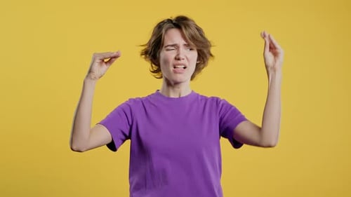 Femme sarcastique agacée montrant des mains gestuelles de Blabla sur fond jaune