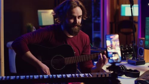 Young Adult Plays Guitar in Home Studio