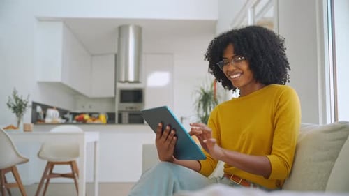 Woman Using Tablet on Couch in Modern Home