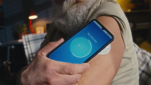 Senior Man Checks Glucose Level on Smartphone