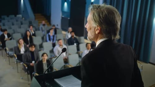 Speaker Presents to Seated Audience in Auditorium